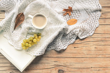 Cup Of Cappuccino On A Tray, Knitted Napkin, Dried Leaves And Bunch Of Grapes. Wooden Background, Autumn Concept. Top View, Flat Lay, Copy Space.