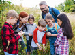 © Halfpoint - Group of school children with teacher on field trip in nature, learning science.