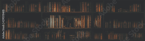 Cuadros en Lienzo panorama blurred bookshelf Many old books in a book shop or library