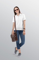 Wall Mural - Standing beautiful woman model wearing white plain polo t shirt in blue denim jeans pant. Carrying brown office bag on her shoulder. Isolated background