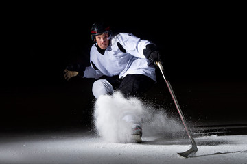 ice hockey player in action kicking with stick