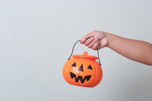 Hand Holding Halloween Pumpkin Bucket