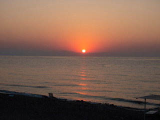 The sun rises from the horizon in the early morning on the sea