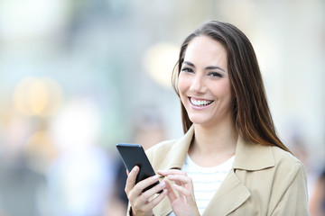 Sticker - Happy woman holds a smart phone looking at camera