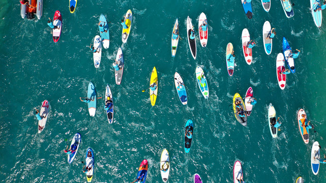 aerial bird's eye view photo taken by drone of stand up paddle surfers in annual sup crossing compet