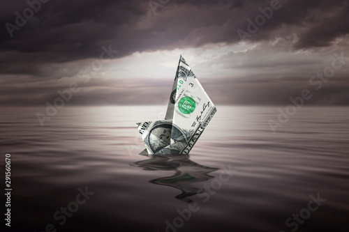 Fotografía Sinking a little boat made with a dollar bill