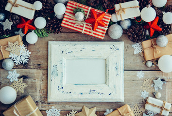 Wall Mural - Christmas background with frame and gift boxes on the wooden tab