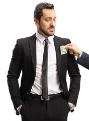 Sticker - Male hand putting money into suit pocket of a businessman