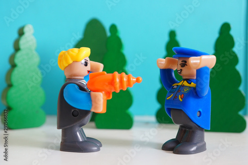 Playtive blond woman figure pointing a laser gun at a police man on April 9, 2019 in Poznan, Poland. : comprar esta foto de stock y explorar imágenes similares en Adobe Stock | Adobe Stock