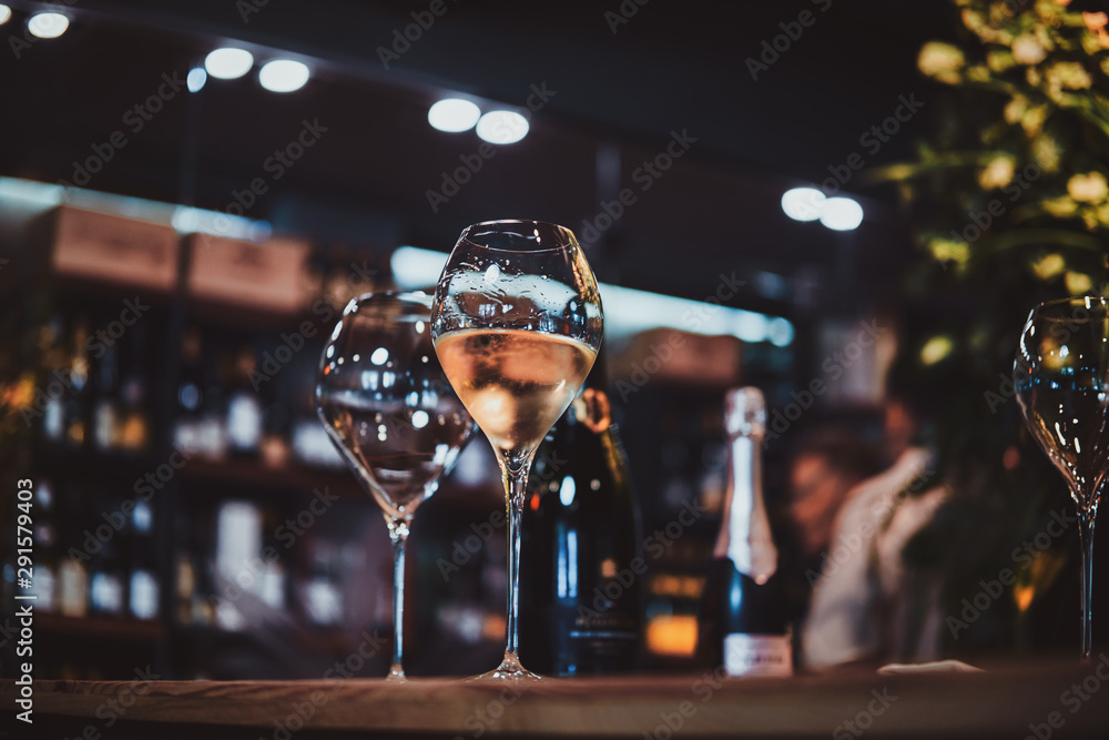 Wine glasses on the bar table, one glass is empty, but the second one is  filled with white wine. Stock Photo | Adobe Stock