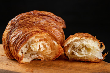 Wall Mural - Tasty fresh croissant on a dark breadboard. Prepared bread on the kitchen table.