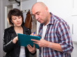 © JackF - Mature man signing papers with social worker at home near door