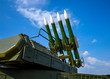 Ballistic missile launcher with four cruise missiles on powerful mobile transportation on background blue sky, antiaircraft forces, military industry