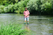 © Volodymyr - Happy fisherman fishing in river holding fishing rods. Trout on a hook. Fish on the hook. Man with fishing rods on river berth. Angler.