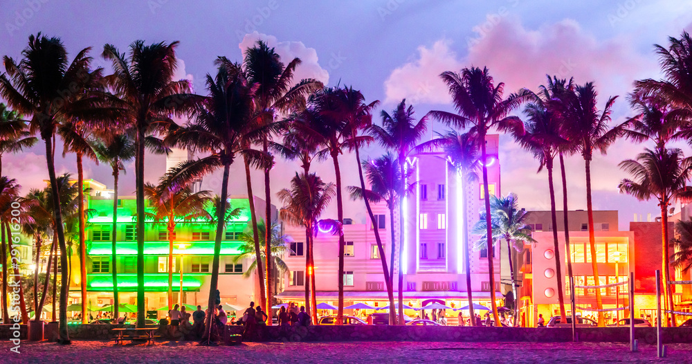 Miami Beach Ocean Drive hotels and restaurants at sunset. City skyline with palm trees at night. Art deco nightlife on South beach - obrazy, fototapety, plakaty 