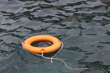 Orange life ring at sea, safety on the water. Lifebuoy on the beach, concept of saving a drowning