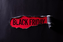 Top View Of Black Torn Paper And The Text Black Friday On A Red Background. Black Friday Composition.