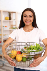 Sticker - Young woman with shopping basket full of products in grocery store