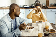 © zinkevych - Smiling dad watching frisky boy playing with cereal.