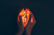 Woman hand holding illuminated garland in her hands in dark
