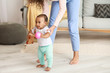© Pixel-Shot - African-American mother teaching her little baby to walk at home