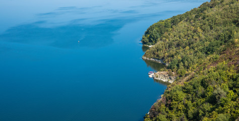 Wall Mural - aerial landscape top view lake blue water and mountain forest green scenic shore line, natural wallpaper poster photography with empty copy space for text 