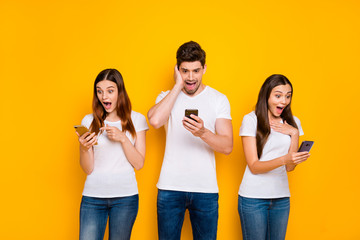 Sticker - Portrait of three nice-looking attractive lovely charming cheerful cheery stunned wondered person using wi-fi connection speed 5g app isolated over bright vivid shine yellow background