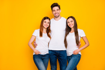 Poster - Portrait of charming fellows looking at camera with beaming smile wearing white t-shirt denim jeans isolated over yellow background