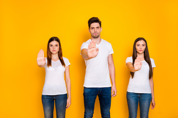 Poster - Portrait of youth holding hand wearing white t-shirt denim jeans isolated over yellow background