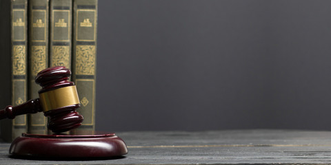 Wall Mural - Law concept - Open law book with a wooden judges gavel on table in a courtroom or law enforcement office