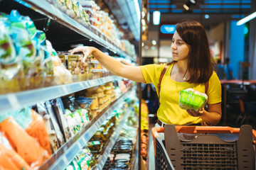 Wall Mural - young pretty adult woman do shopping in grocery store