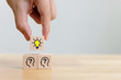 Concept creative idea and innovation. Hand choose a wooden cube block with light bulb and head human symbol icon