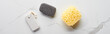 panoramic shot of light and dark gray pumice stone and bath sponge on marble surface