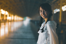 Asian Young Woman Standing Alone, Pretty Girl Smiles And Happy For The Holiday Trip,Train Station Background And Natural Light, Vintage Style.