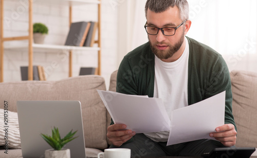 Fotomural Man holding documents with both hands, reading it