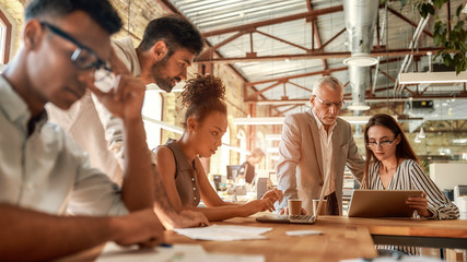 Busy day. Group of business people working together and communicating in the modern office