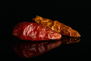 Group of two whole dry red chili pepper peperoncino isolated on black glass