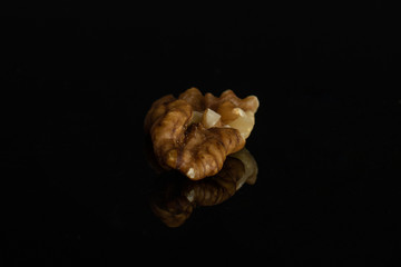 One whole front focus brown almond nut isolated on black glass