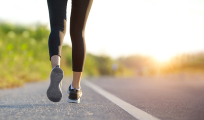 Wall Mural - Young fitness sport woman running on the road in the morning, Young fitness sportswoman runner running on tropical park trail. People and sport concept 