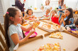 © oksix - Children eating pizza in the kitchen, close up girl