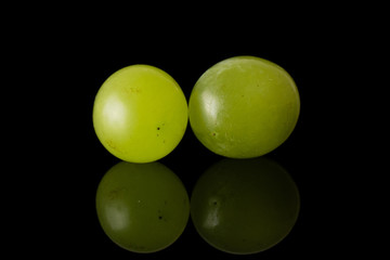 Group of two whole fresh green grape isolated on black glass