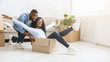 © Prostock-studio - Young man pushing box with his woman, moving in
