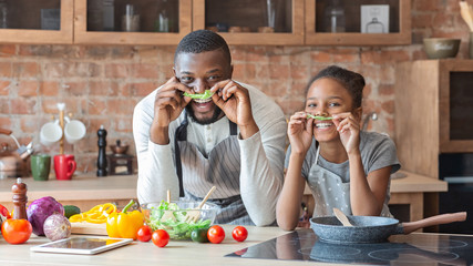 Wall Mural - Father and daughter making mustaches with lettuce