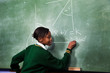 © Greatstock - A young girl solving a math sum on a blackboard