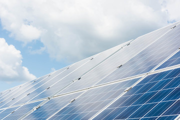 cloudy sky and blue solar energy batteries with copy space