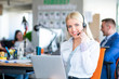 © FS-Stock - Portrait of a smiling creative businesswoman with earpiece in office