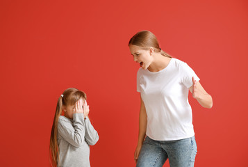 Poster - Angry mother scolding her little daughter on color background