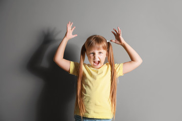 Wall Mural - Portrait of angry little girl on grey background