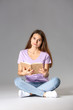 © Pixel-Shot - Young girl with book on grey background