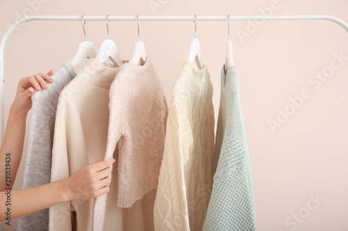 Fotografía Woman choosing clothes hanging on rack